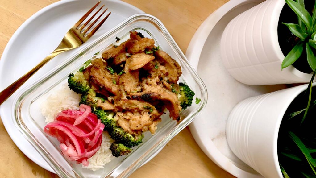 Meal prep container with coconut lime soy curls, broccoli, pickled red onion